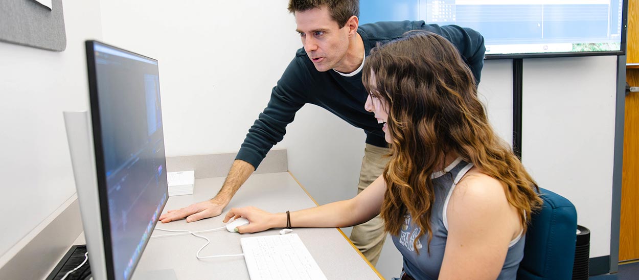 Associate Professor David Safin assisting a student on a project in the computer lab