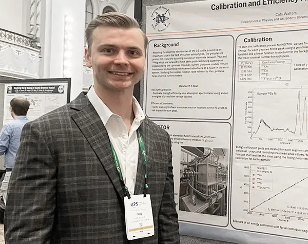 Coty Walters standing next to the poster explaining the outcomes of his experiment at the annual 2024 Division of Nuclear Physics