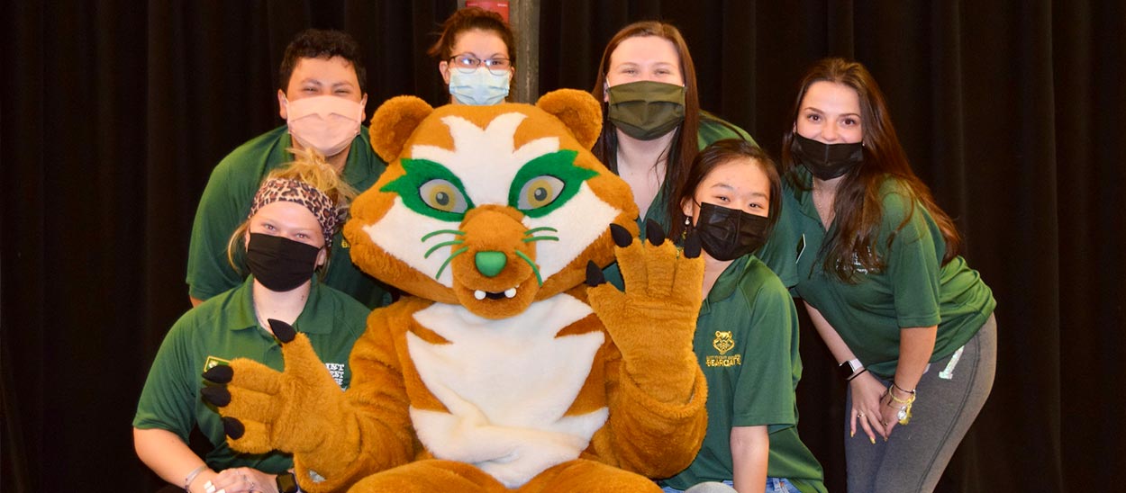 group photo of students wearing face masks posing with Vinnie the Saint Vincent mascot.