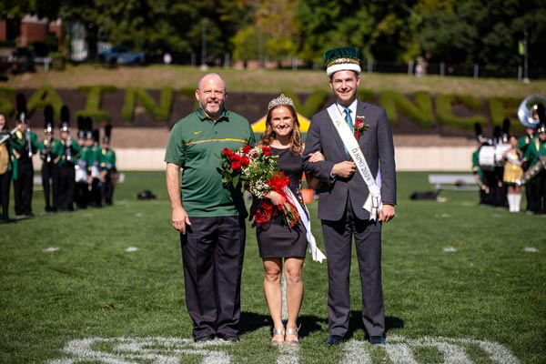 Father Paul Taylor, O.S.B., Saint Vincent College President, poses for a photo with Hartner and Seftas after the two were crown queen and king.