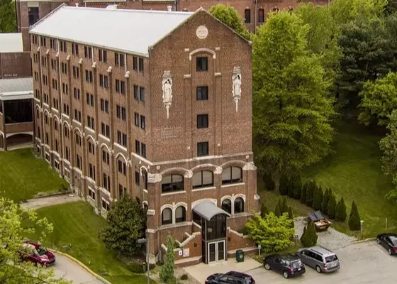 Aurelius Hall, an historical brick building with decorative elements, surrounded by greenery.