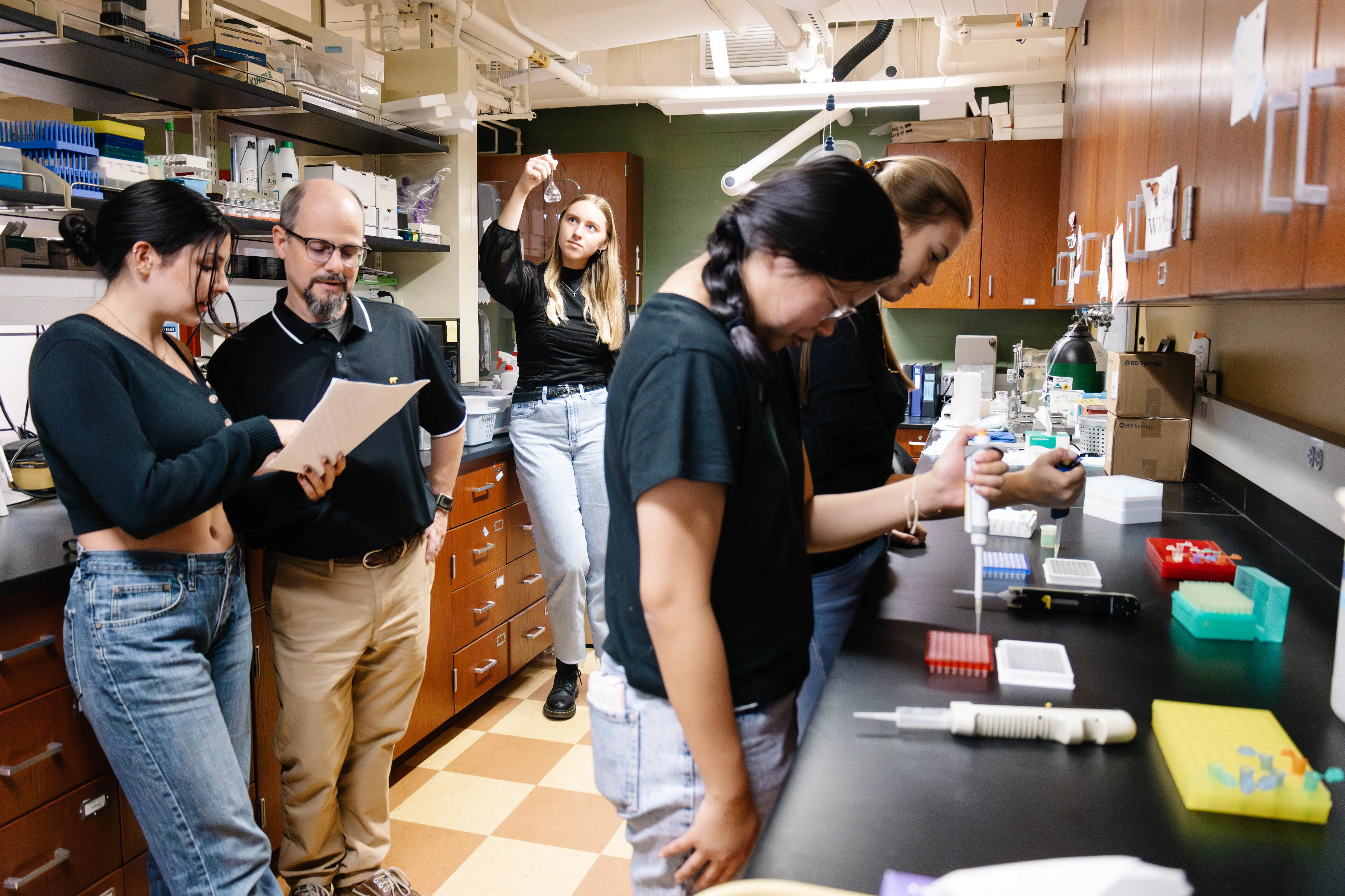 A group of researchers working collaboratively in a laboratory, engaging in various scientific tasks with lab equipment.