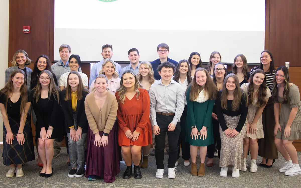 Group photo of a diverse group of students posing together in formal attire at an event.