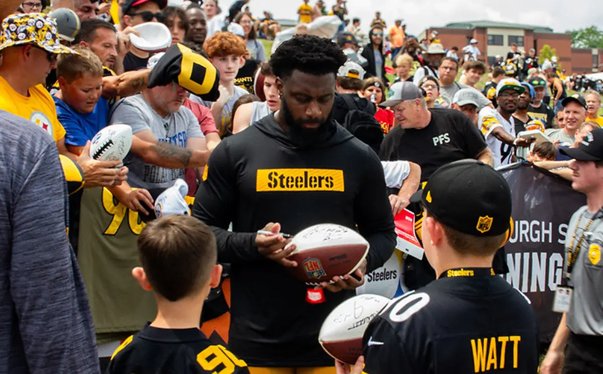 Pittsburgh Steelers player signing autographs for young fans during a team event.