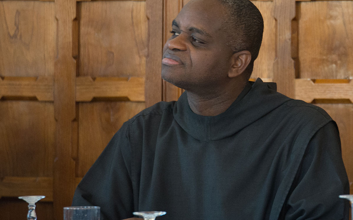 Father Pachomius Okogie sitting at a table